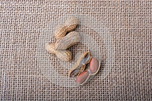 Cracked open peanuts with shell on a linen canvas