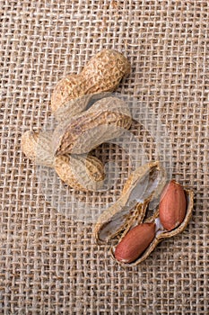 Cracked open peanuts with shell on a linen canvas