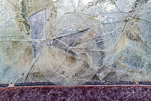 The cracked rear window of a rusty antique car