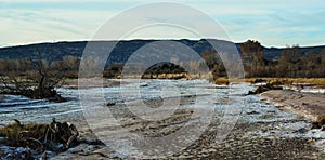 Cracked red clay and white salt on the surface in a dried riverbed in the desert of New Mexico, USA