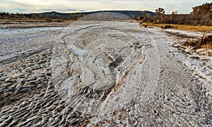 Cracked red clay and white salt on the surface in a dried riverbed in the desert of New Mexico, USA