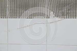 Cracked and repaired tiles with gray comb background