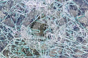 Cracked and shattered glass. Abstract texture and background. Broken glass close-up on the ground