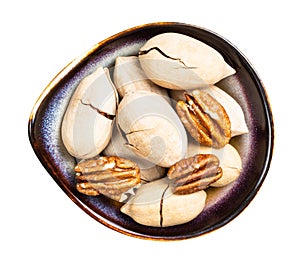 Cracked and shelled pecan nuts in bowl isolated