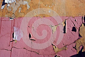 Cracked soft pink paint, plaster surface on yellow brick wall, grunge horizontal shabby background detail