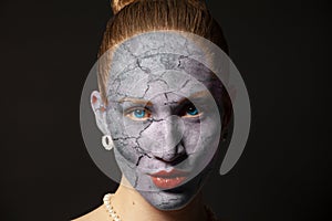 Cracked surface on woman face. Dry skin concept.