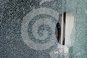 Cracked tempered glass with cracks pattern. Vandalism, destruction concept. Broken glass due to crime