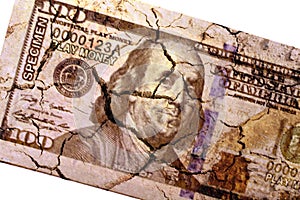Cracked US paper dollar currency on isolated white
