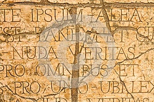 Cracked wall with Latin inscriptions and Roman letters.