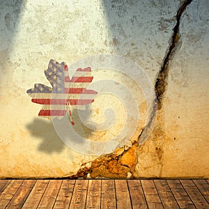 Cracked wall and maple leaf with symbolic american colors