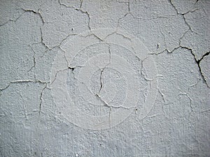 Cracked White colored wall exposed to open air forms texture