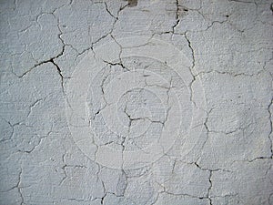 Cracked White colored wall exposed to open air forms texture