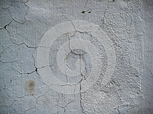 Cracked White colored wall exposed to open air forms texture