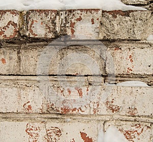 Cracked white plaster on old brickwork, close-up, grunge brick wall with space for text