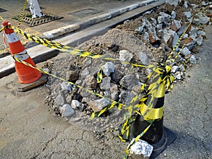 Cracked and worn asphalt on a street work. Broken concrete on a public way. Cones delimiting street work area in Sao Paulo, Brazil