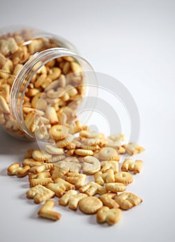 Cracker or Cookie ABC letter alphabet in glass  with copy space on white background pile on the floor