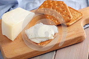 Crackers with Gouda Goat Milk Cheese on wooden board
