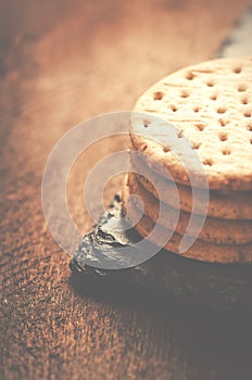 Crackers stack together on black stone, wooden background.Copy s