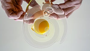 Cracking chicken egg on transparent surface.