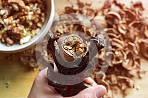 Cracking walnut nutcracker in hand on the background of the slides of the shell