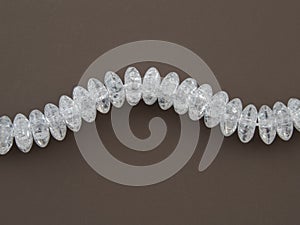 Crackle glass or Sugar quartz beads on a brown background