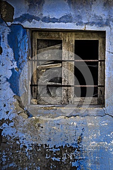 Cracks on a blue wall and old window