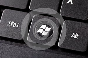 The Windows button on a black laptop notebook keyboard macro extreme closeup top view Round dedicated operating system key