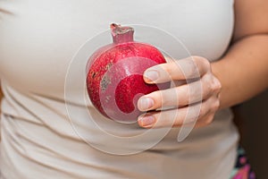 Cradling a Whole Pomegranate. Holding a whole ripe pomegranate in the palms