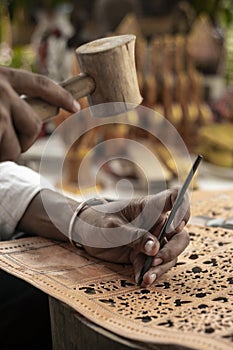 Craft artist making traditional buffalo leather carving art in indonesia