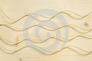 Craft backgorund with wavy packthread ropes on wooden surface