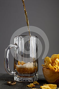 craft beer is being poured into a glass mug with handle in a pub with dark background
