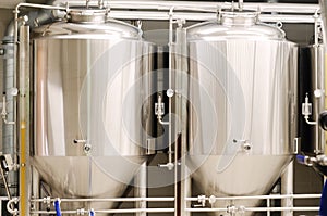Craft beer brewing equipment in the brewery. Modern beer plant. Metal tanks, process of alcoholic drink production.