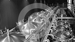 Craft beer production line in private microbrewery. Modern beer plant with brewering kettles, tubes and tanks made of