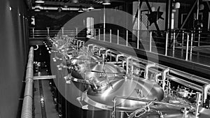 Craft beer production line in private microbrewery. Modern beer plant with brewering kettles, tubes and tanks made of