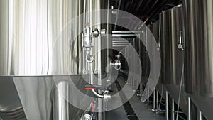 Craft beer production line in private microbrewery. Modern beer plant with brewering kettles, tubes and tanks made of