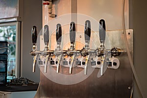 The craft beer taps at restaurant. Alcohol beverage ready to party