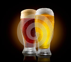 Craft beer. Two glasses of cold light and dark beer isolated on black