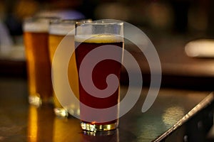 Craft beer on wooden table with blurred background in night club