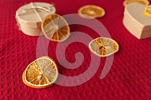 Craft box and dried oranges on a red background with copy space. Healthy sweets concept. Flat lay