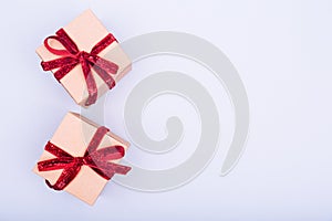 Craft boxes with red ribbon bows. Holiday, Christmas, New Year and Valentine day eco-friendly wrapping concept. Trendy