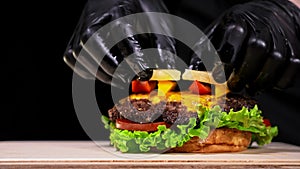 Craft burger is cooking. Consist: red sauce salsa, lettuce, red onion, pickle, cheese, chilli green pepper, air bun and