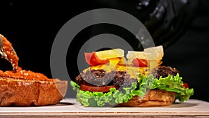 Craft burger is cooking. Consist: red sauce salsa, lettuce, red onion, pickle, cheese, chilli green pepper, air bun and