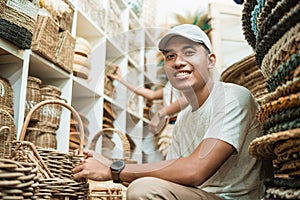 craft buyer holding a woven basket bag and smiling at camera