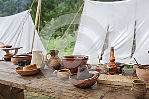 Craft ceramist shows clay jars and pots at potter workplace on festival workshop, artisanal ware