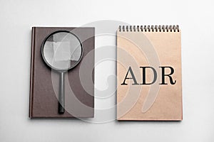 Craft colour notepad with text adr. Notepad with , magnifying glass. Business concept