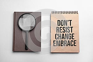 Craft colour notepad with text Dont resist change embrace. Notepad with , magnifying glass. Business concept