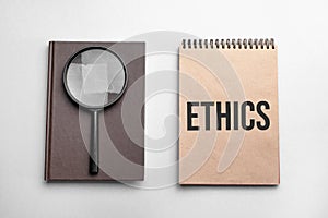 Craft colour notepad with text ETHICS. Notepad with , magnifying glass. Business concept