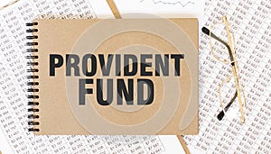 Craft colour notepad with text PROVIDENT FUND. Notepad with eyeglasses and text documents. Business concept