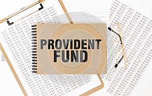 Craft colour notepad with text PROVIDENT FUND. Notepad with eyeglasses and text documents. Business concept