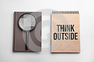 Craft colour notepad with text Think Outside. Notepad with , magnifying glass. Business concept